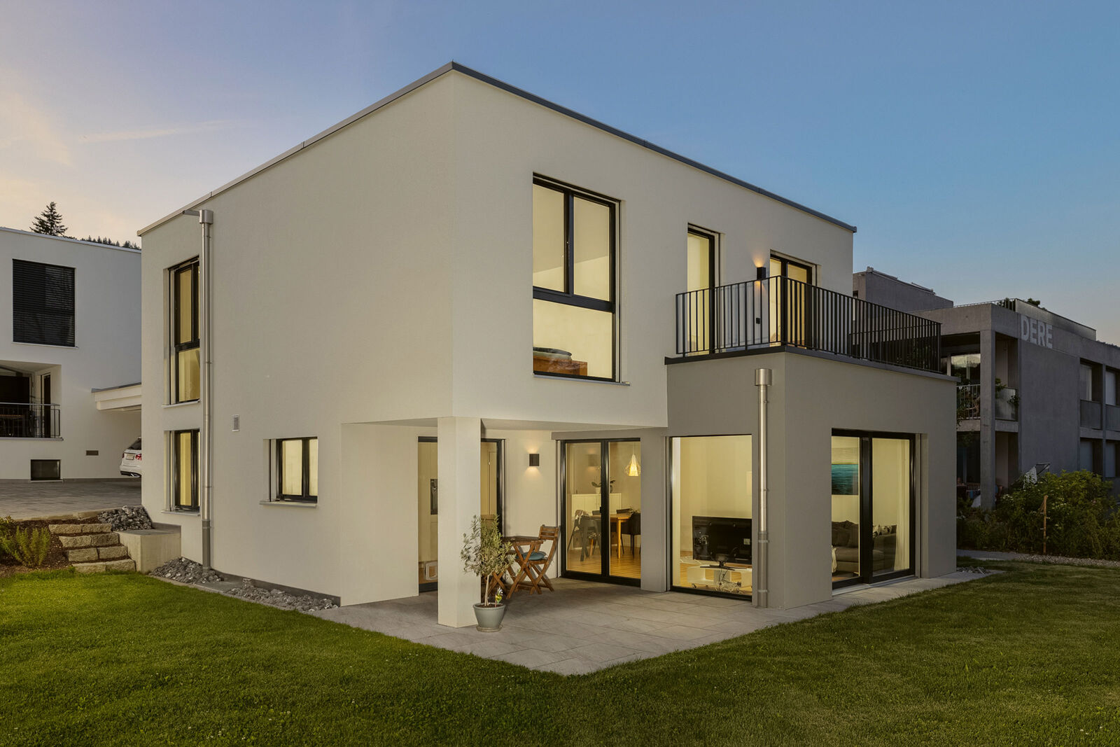 Von aussen überzeugt das Haus mit moderner Architektur. Vom Wohn- und Kochbereich gelangt die Familie direkt auf den wind- und wettergeschützten Sitzplatz.